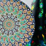 خرید بشقاب میناکاری روی سفال با قطر ۴۰ سانتی‌متر، زمینه سبز و رنگ‌های شاد؛ محصولی دست‌ساز و لعاب‌دار برای پذیرایی، دکوراسیون و هدیه.
