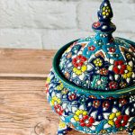 شکلاتخوری سفالی دستساز سهپایه با ارتفاع ۲۰ سانتیمتر، نقوش مینای برجسته و زمینه سورمهای یا آبی